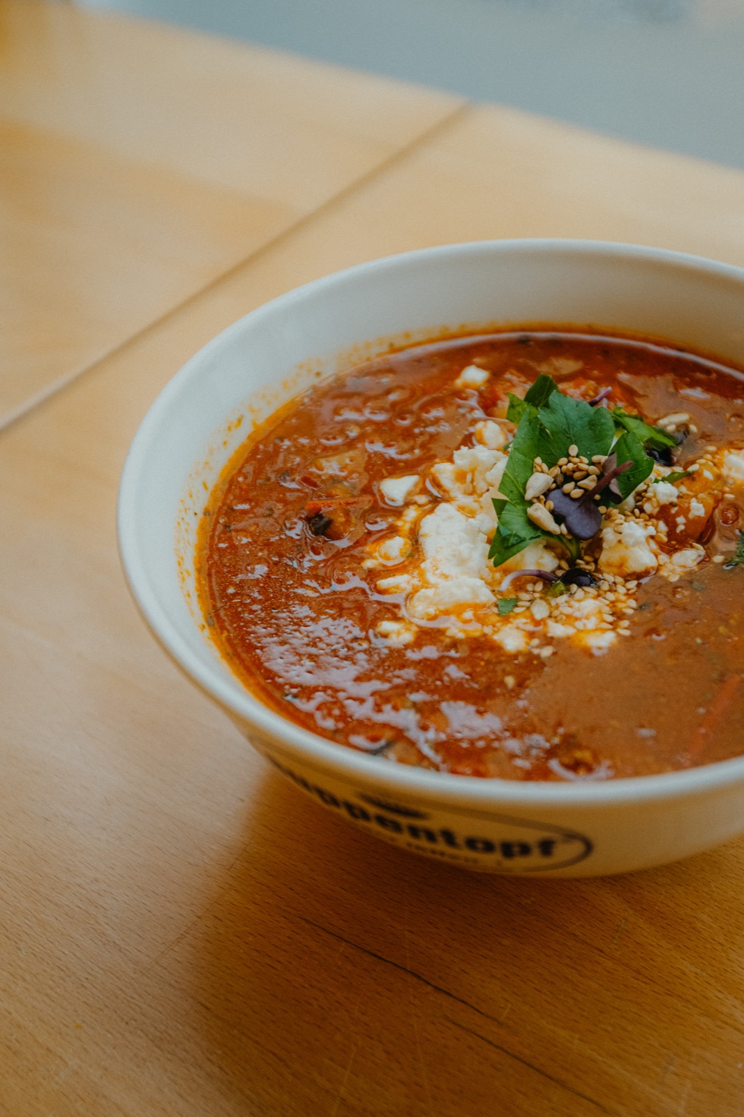 Frisch gekochte Suppe mit Feta und Kräutern beim Mittagstisch im Suppentopf